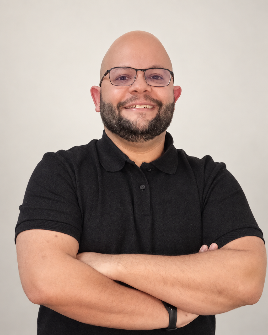 Leonardo Cruz sorrindo, com óculos e camisa polo preta